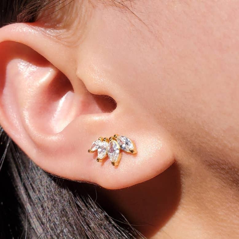 Close-up of model wearing a gold-plated sterling silver ear climbers There are 4 marquis-cut white cubic zirconia set in a slight angle to create a shallow curve. 